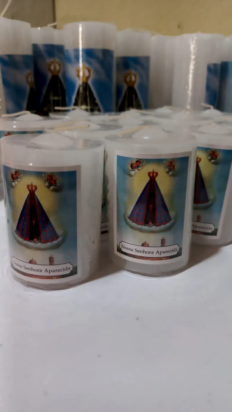 Velas brancas com a imagem de Nossa Senhora Aparecida