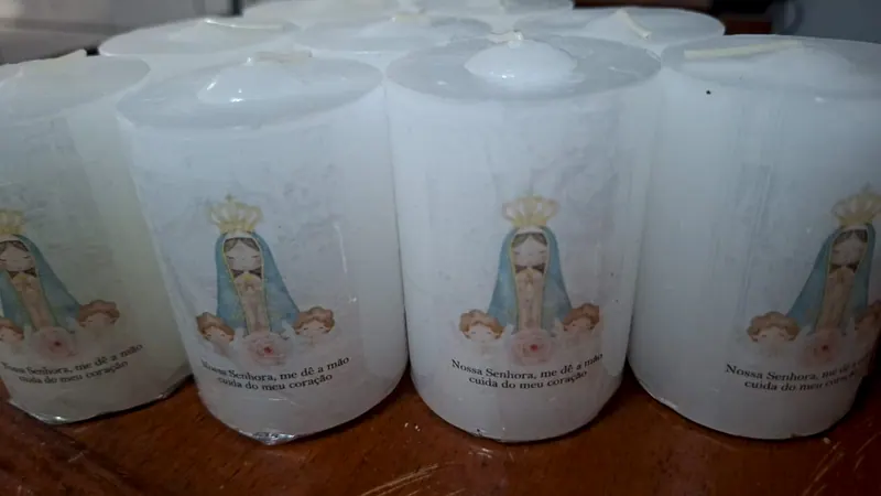 Velas baixas brancas com Nossa Senhora e a frase Nossa Senhora, me dê a mão, cuida do meu coração