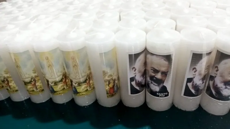 Velas brancas com a imagem de Santo Pio e de Nossa Senhora de Fátima